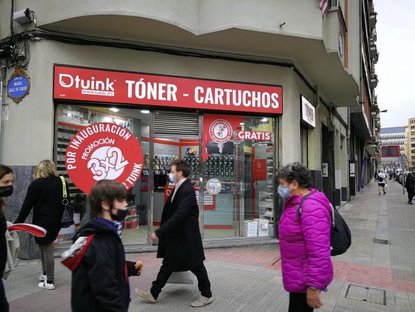 Calle comercial en Bilbao con tiendas que ofrecen tinta y tóner para impresoras